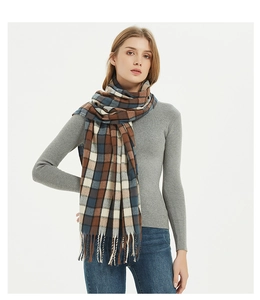 Detail of classic plaid scarf with fringe tassels in caramel, blue and beige tones