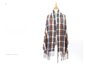 Close-up of classic plaid pattern and handmade tassel details on the thick winter scarf