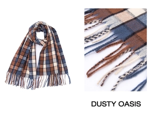 Detail view of plaid scarf fabric texture and hand-woven tassels in brown and blue
