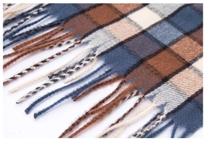 Detail of blue and brown checkered scarf featuring high-density knit and long fringe edges