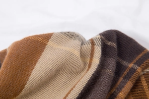 Gros plan sur un tissu tricoté à carreaux doux marron et beige pour écharpes d'hiver