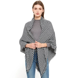Sciarpa in cashmere pied de poule bianco e nero con frange indossata da modella