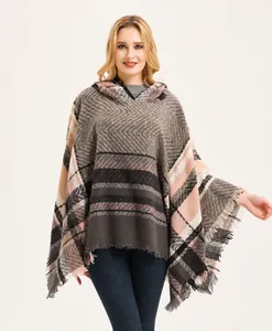 Detail van meerkleurige gebreide poncho met geruit patroon, bouclé garen en franje rand