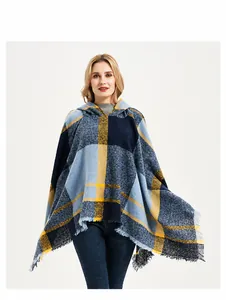 Detail eines blau-gelben Karo-Ponchos mit Fransen am Saum und strukturierter Strickware
