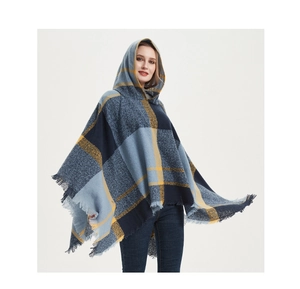 Detail eines blau-gelb karierten Kapuzen-Ponchos mit Fransen und weicher Strickstruktur