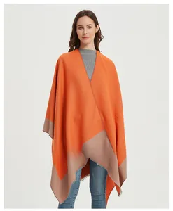 Detail view of orange and taupe color block knit shawl with elegant fringe trim
