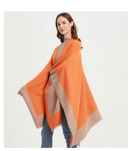 Detail of color-block poncho with orange and beige knit fabric and fringe edges
