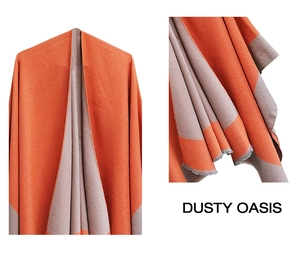 Detail of orange and grey knit shawl with delicate fringe edges and split design