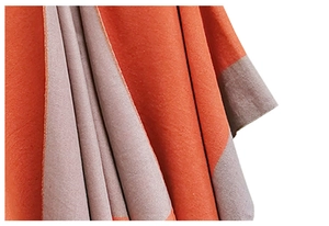 Detail of soft knit texture showing orange and taupe color block scarf fabric