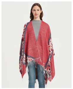 Close-up of red and grey knit poncho with leopard print borders and white fringe detail