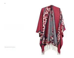 Detail of red and grey leopard pattern knit poncho with white tassel fringe accents