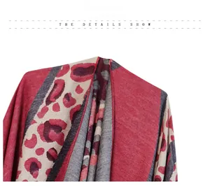 Close-up of knit leopard print shawl in red and grey showing detailed textile texture