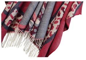 Detailed close-up of leopard print shawl featuring red grey tones and white fringe edges