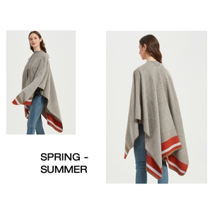 Detail view of grey knit plaid poncho with orange striped hem and split side design