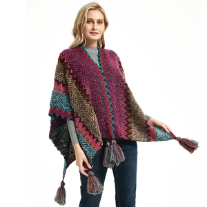 Bohemian knit poncho featuring colorful wave patterns and thick decorative tassels