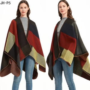Dettaglio dello scialle in maglia color-block con motivi geometrici e bordo a punto pieno