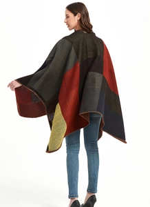 Dettaglio del poncho geometrico con rifinitura overlock fine e blocchi di colore