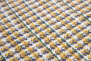 Gros plan sur un tissu en tweed multicolore avec motif pied-de-poule et fils argentés