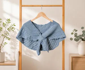 Détail d'un châle tricoté bleu clair avec motif ajouré et fermeture à lacets élégante