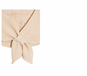 Détail d'un châle en maille ajourée beige avec texture côtelée et bords ondulés chic