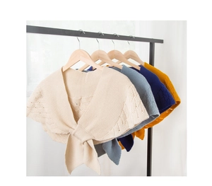 Details des durchbrochenen Strickmusters und der dekorativen Bänder in verschiedenen Farben