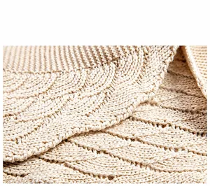Gros plan du châle en tricot beige avec un motif ajouré ondulé délicat et élégant