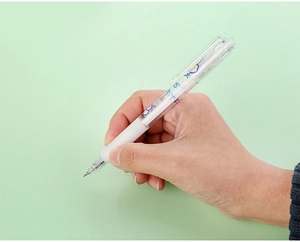Close-up of a hand holding a cute retractable craft knife pen with cloud pattern