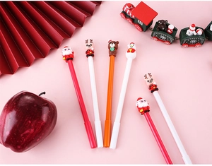 Close-up of Christmas gel pens featuring Santa, reindeer and snowman toppers in festive setting