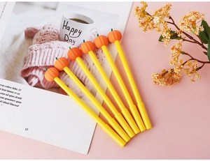 Set of six creative pumpkin gel pens for Halloween on a minimalist pink surface