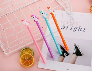 Close-up of four colorful unicorn cartoon pens with 3D silicone tops on a pink background