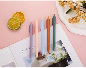 Set of 5 Morandi matte retractable gel pens displayed with creative office props