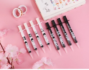 Close-up of syringe-shaped gel pens with creative text and cartoon prints in a pink set