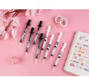 Creative syringe-shaped gel pens with cartoon graphics on a pink decorative background