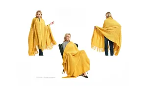 Detail of ginger yellow knitted shawl featuring diamond patterns and long decorative tassels