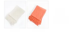Detail of knitted throw blanket showing cream white and watermelon red tassel fringes