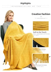 Detail of yellow knit throw blanket with textured diamond pattern and elegant tassels