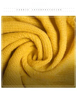 Macro shot of warm yellow knitted throw blanket showing soft texture and premium weave