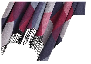 Détail du tissu doux aux motifs géométriques rouges et gris avec des pompons noirs