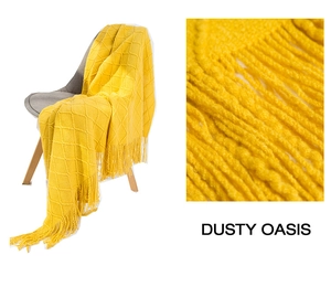 Close-up of bright yellow knit blanket featuring diamond patterns and long tassel fringe