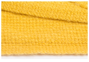 Macro detail of vibrant yellow knitted blanket showing soft texture and woven pattern