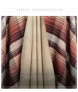 Close-up of red and black tartan fabric with soft beige lining and textured weave