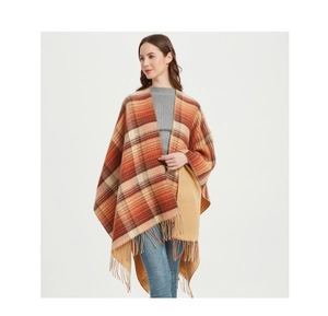 Detail of the soft knit texture and fringe hem on the orange and brown plaid shawl