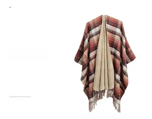 Detail of red and orange plaid reversible shawl featuring fringe trim and beige interior