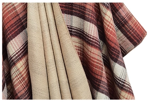 Close-up of double-sided knit shawl showing red plaid pattern and camel lining detail