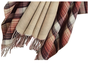 Detail of reversible plaid shawl with red and brown checks and soft fringe edges