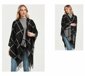 Detail of checkered knit poncho with fringe hem and dusty oasis pattern design