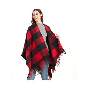 Detailed view of red and black buffalo check poncho shawl featuring long tassel fringe trim