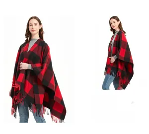 Detail of red and black buffalo plaid poncho with thick knitted fabric and fringe hem