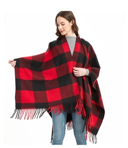 Detail of red and black buffalo check shawl featuring long fringe trim on thick fabric