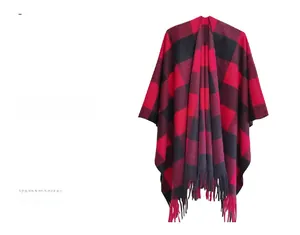 Detail of red and black buffalo plaid knitted poncho with thick decorative tassels